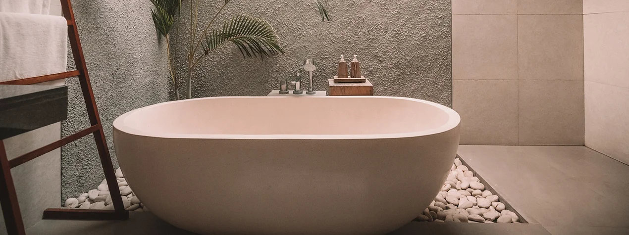 Badkar i modern stil med djupa och rundade kanter i badrum med grå och beigea toner